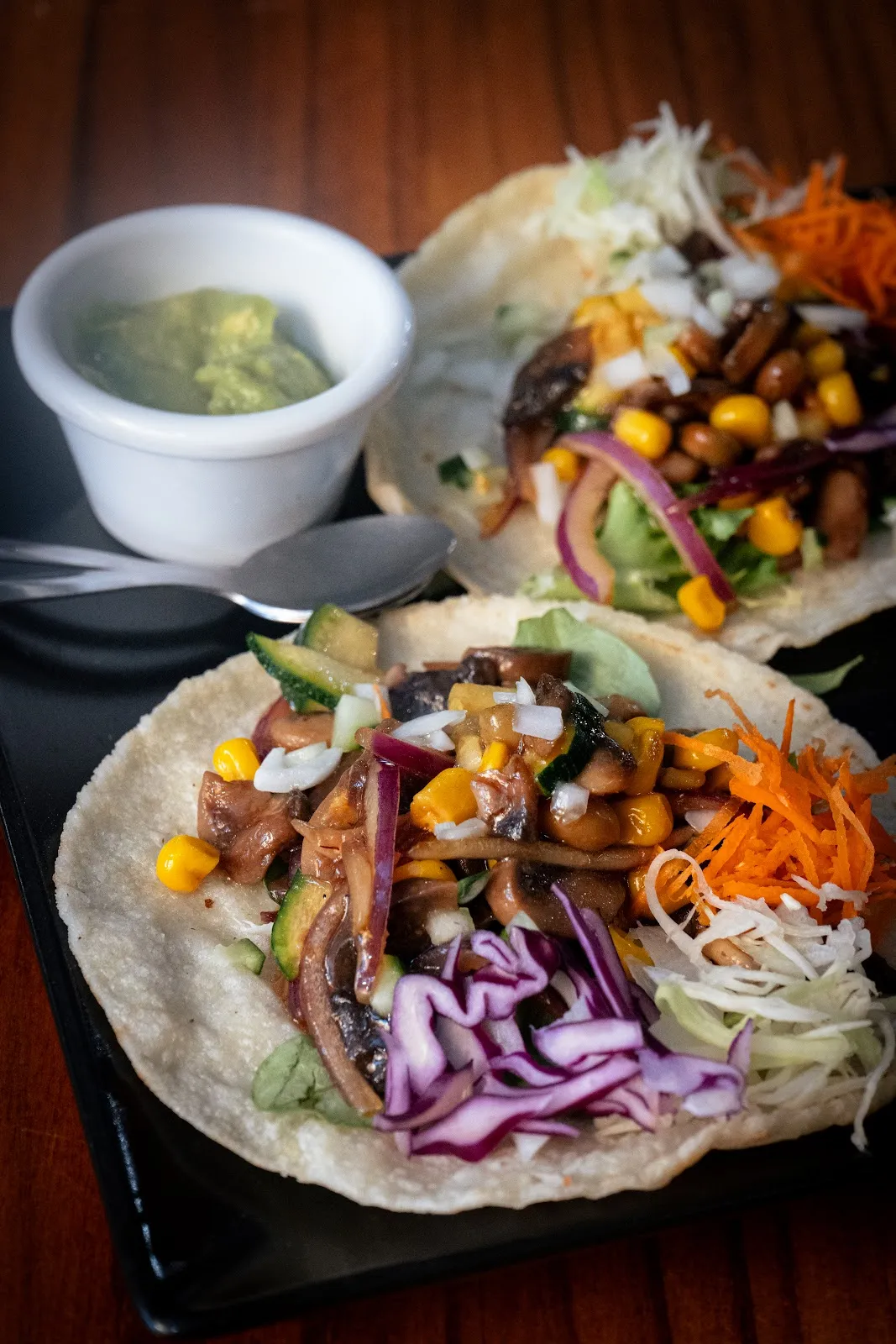 Dos tacos en tortilla de maíz con verduras y guacamole